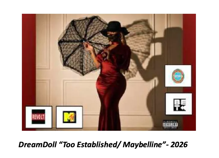 Still from DreamDoll's music video — the artist in a floor-length red satin gown and wide black hat, holding a patterned lace umbrella against a pale panelled wall.